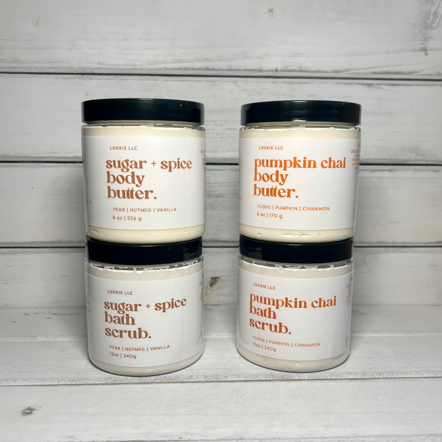 Complete collection of Autumn Bliss Season Collection. Features Sugar and Spice Whipped Body Butter, Foaming Sugar Exfoliating Shower Scrub. Pumpkin Chai Triple Butter Whipped Body Butter and Foaming Sugar Shower Scrub. Lids on, front view.